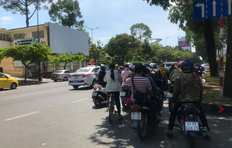 Nắng nóng giữa trưa khiến người đi lại trên đường ở TP HCM vô cùng khó chịu...