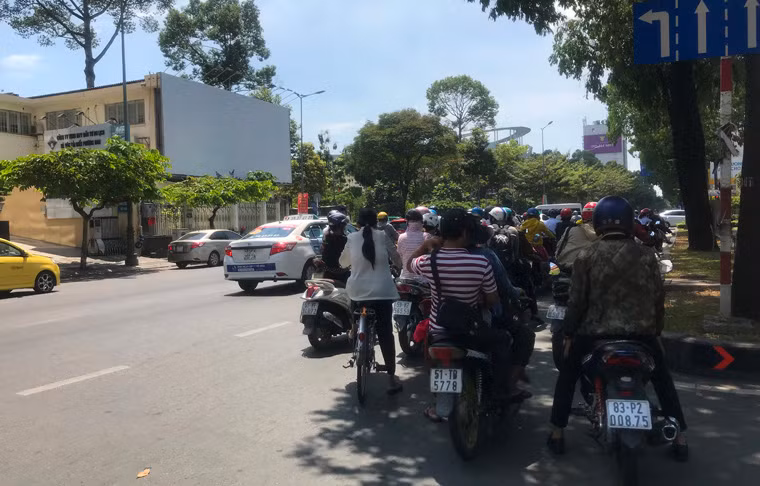 Nắng nóng giữa trưa khiến người đi lại trên đường ở TP HCM vô cùng khó chịu...