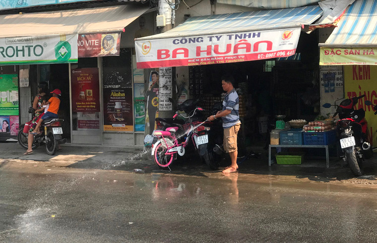 Người dân liên tục tưới nước để làm mát nhiệt độ vì nắng nóng gây oi bức, khó chịu.