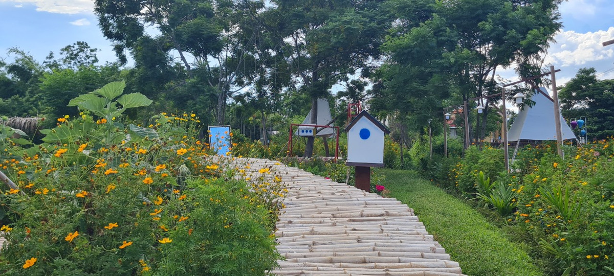Du khách lạc bước trên những con đường quanh co được ghép bằng tre, tô điểm bởi nhiều tiểu cảnh và các loài hoa dại.