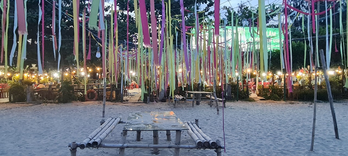 Và ngay dưới chân cầu, dãy nhà hàng hải sản nổi tiếng, nơi du khách thường dừng chân sau khi dạo bước ngắm hoàng hôn, đã sáng đèn rực rỡ.