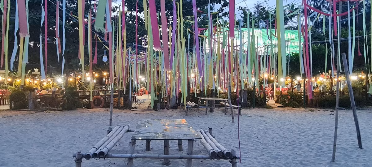 Và ngay dưới chân cầu, dãy nhà hàng hải sản nổi tiếng, nơi du khách thường dừng chân sau khi dạo bước ngắm hoàng hôn, đã sáng đèn rực rỡ.