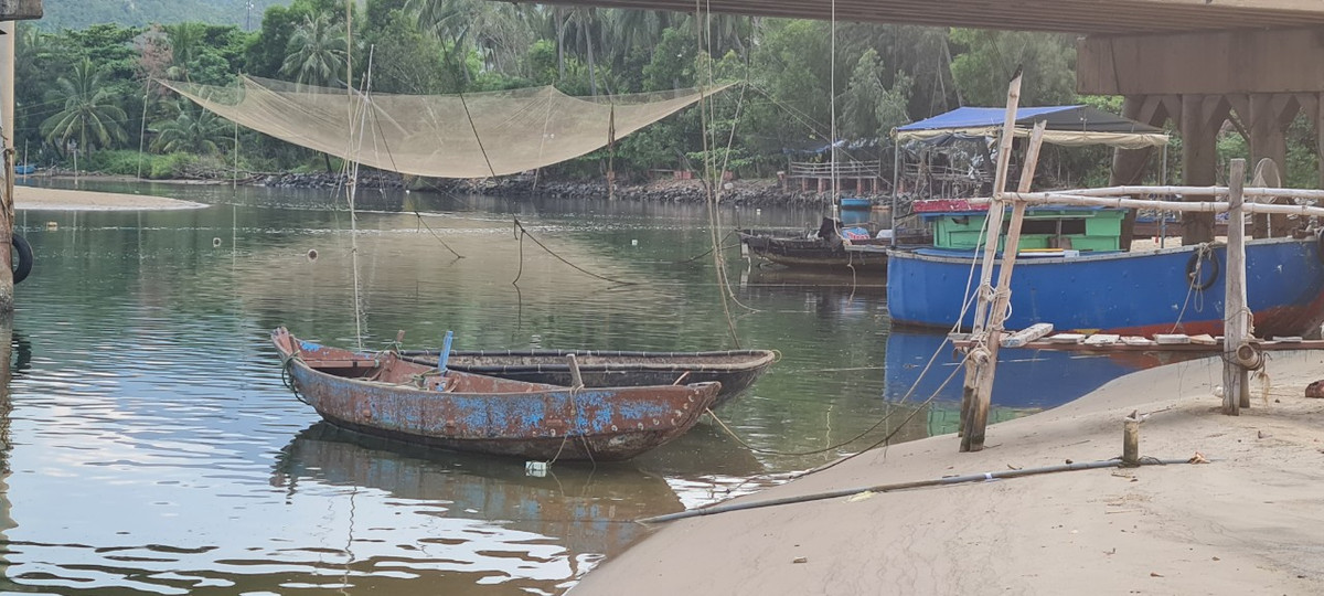 Hai bên bờ sông, ngay dưới chân cầu là những chiếc vó lưới và thuyền bè ngư dân đang neo đậu…