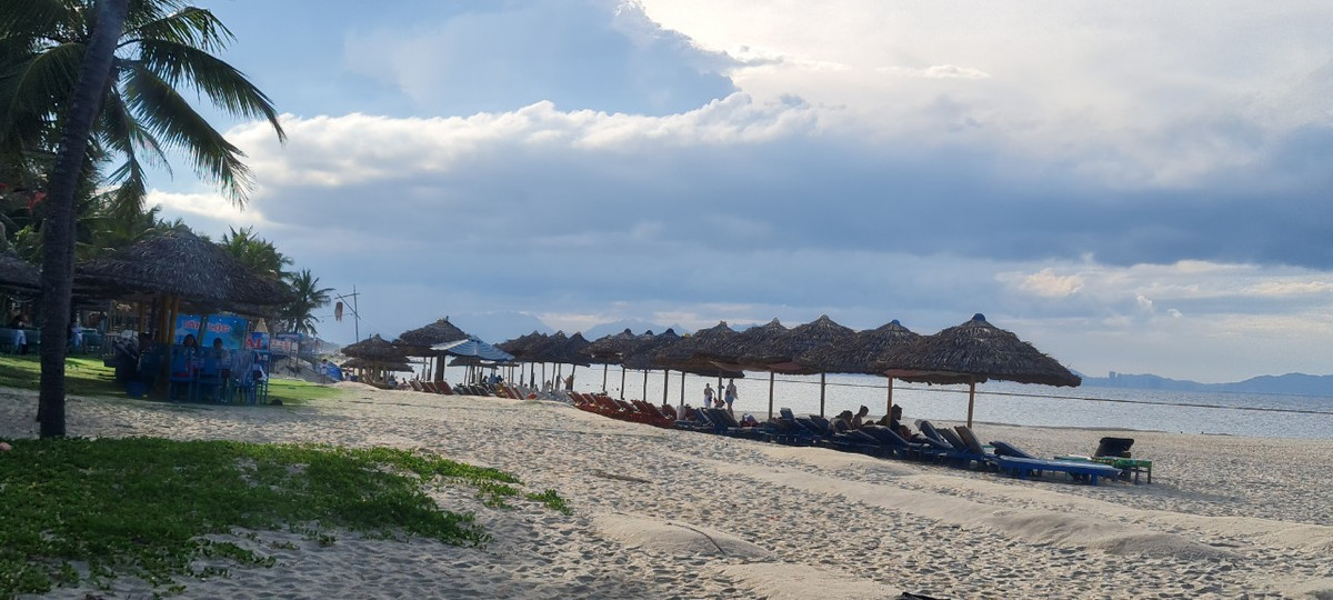 Trên bãi cát dài, một resort đã dựng lều, đặt bàn ghế đón du khách tắm biển, nghỉ ngơi.