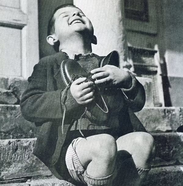 Bức “Đôi giày mới” do nhiếp ảnh gia Gerald Waller chụp năm 1946 cho tạp chí Life (Mỹ), ghi lại hình ảnh cậu bé 6 tuổi người Áo có tên Werfel, cậu bé sống trong một trại trẻ mồ côi ở Áo, khi được Hội Chữ thập đỏ Mỹ trao tặng phần quà là một đôi giày mới với biểu cảm vô cùng hạnh phúc.