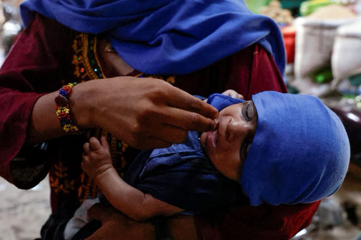 Người mẹ dùng ngón tay cho con mình uống nước.