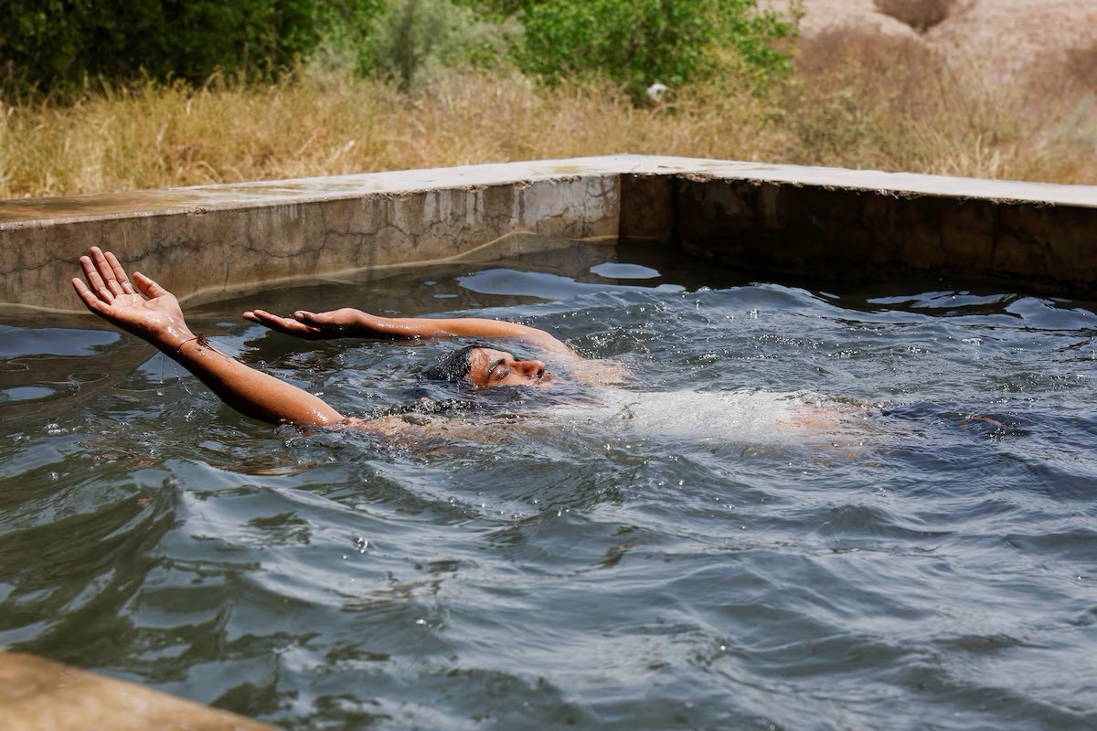 Một bé trai ngâm mình trong bể bơi để hạ nhiệt trong một ngày hè nóng kỷ lục ở Mohenjo Daro.