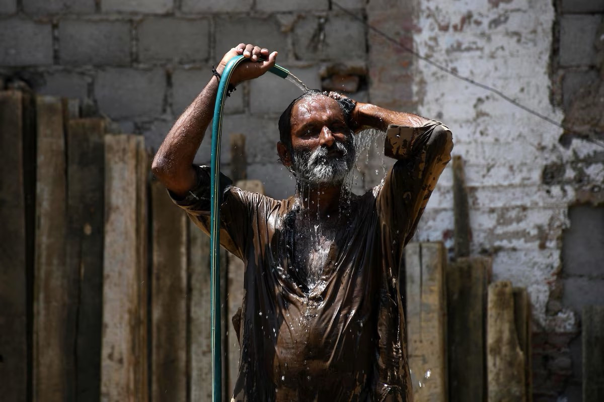 Một người đàn ông tắm dưới vòi nước để giải nhiệt ở Hyderabad.