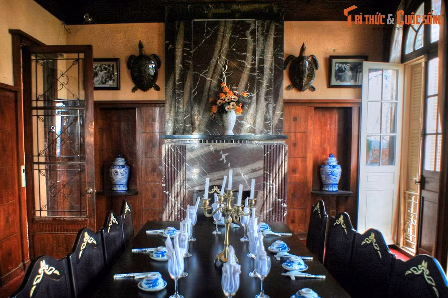 Phòng yến tiệc gây ấn tượng mạnh với bộ bàn ghế gỗ sang trọng có họa tiết dát vàng, lò sưởi ngoại cỡ bằng đá hoa cương đen vân trắng, hai bên trang trí bằng hai con đồi mồi.