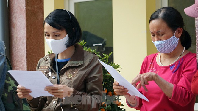 Cầm phiếu xác nhận trên tay, chị Hường (trái ảnh) mừng rỡ. Chị là một trong nhiều người về quê ở Hải Dương và Quảng Ninh giữa tháng 1 phải đi cách ly tập trung.