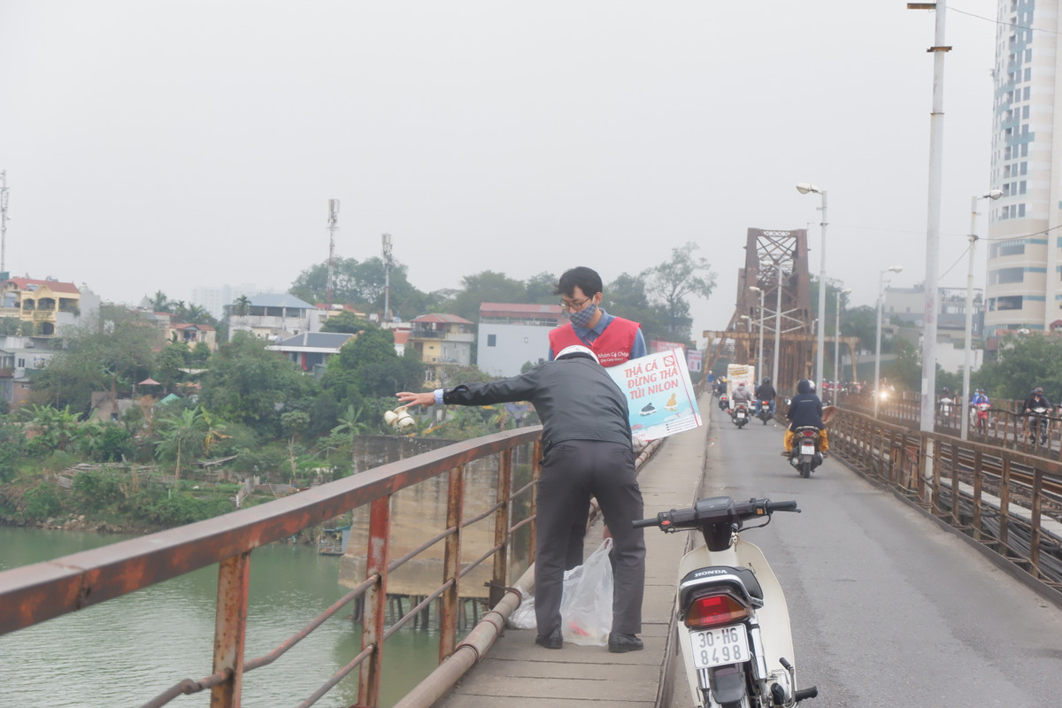 Mặc dù có người đến nhắc nhở tuy nhiên người đàn ông này vẫn thản nhiên thả cá và vứt đồ xuống sông Hồng.