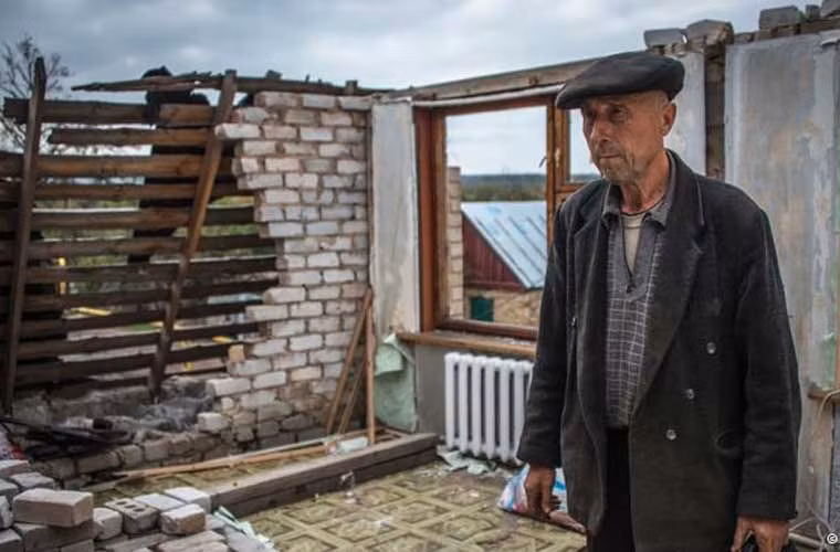 Khi màn đêm buông xuống, các loại đạn pháo vẫn liên tục nã xuống các vùng chiến tuyến Ukraine quanh Donetsk cho tới tận tờ mờ sáng hôm sau. Ảnh: Ông lão Ivan Polansky đang xem thiệt hại trong ngôi nhà bị tàn phá bởi các vụ giao tranh ác liệt giữa quân đội chính phủ và lực lượng khai ở miền đông Ukraine. Ảnh DW