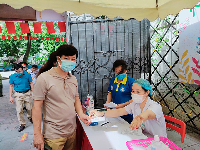 Sau khi cử tri được đo thân nhiệt, xịt cồn khử khuẩn sẽ được hướng dẫn các bước thực hiện bầu cử.