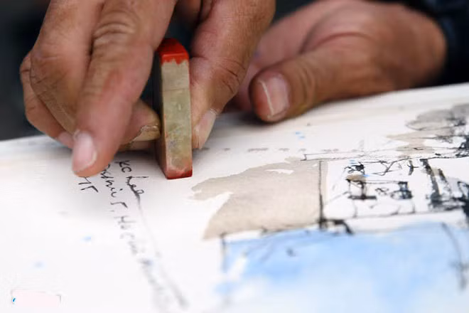 Họ thường sử dụng ấn triện để làm chữ ký. Ông Lee điểm ấn trước khi tặng một bạn trẻ Việt Nam tham gia đoàn sáng tác.