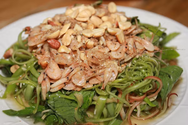 Gỏi rau muống tép sông. Tép sông con nhỏ, rửa sạch, để ráo, đem rang chín với một chút dầu ăn. Lạc khô rang chín, xát bỏ vỏ và đập dập, húng quế đem rửa sạch thái nhỏ, ít hoa chuối rửa sạch để ráo. Tỏi bóc vỏ, giã dập, ớt thái sợi, bỏ hạt. Cho tỏi, ớt, nước cốt chanh cùng ít đường, mì chính khuấy đều cho tan. Rau muống, hoa chuối trộn với tỏi ớt chua ngọt, sau đó cho hung quế và tép vào, kế tiếp là lạc rang lên trên. Dùng đũa trộn đều các hỗn hợp. Khi ăn bạn sẽ cảm nhận được đủ các vị chua, cay, mặn, ngọt và cả vị giòn giòn rất thú vị từ rau muống.