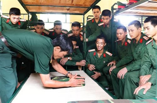 Cán bộ trung đội hướng dẫn gấp chăn màn.