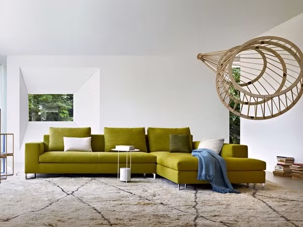 Bộ sofa lớn với gam màu xanh này không chỉ đáp ứng chỗ ngồi cho cả đại gia đình mà còn là điểm nhấn ấn tượng cho căn hộ nhỏ sử dụng sắc trắng. Cùng với sofa, chiếc đèn trang trí ấn tượng cũng phát huy được tác dụng trang trí khiến phòng khách này đẹp hơn.