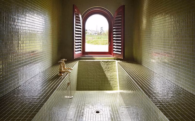 Phòng tắm được làm bằng gạch men xanh tạo nên vẻ sang trọng cho ngôi nhà.