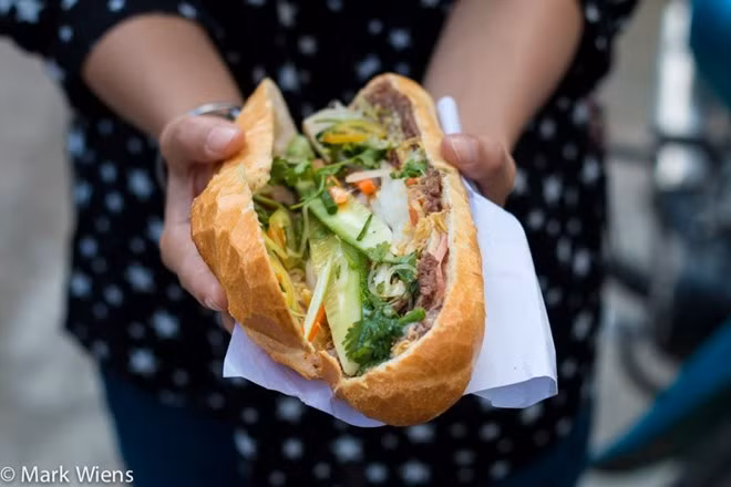 Bánh mì, Việt Nam: Lớp vỏ giòn cùng phần nhân hấp dẫn từ thịt, patê, rau thơm, dưa góp, thêm tương ớt, mayonaise... có thể chinh phục những thực khách khó tính nhất. Bạn có thể thưởng thức món ăn đường phố này ở khắp Việt Nam, với giá khoảng 1-2 USD. Ảnh: Mark Weins.