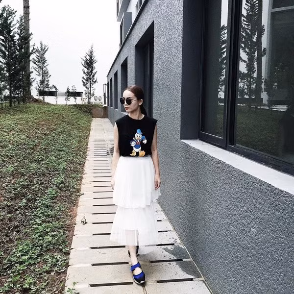 Yến Trang kết hợp váy xếp ly nhiều tầng độc đáo cùng áo phông họa tiết hoạt hình tinh nghịch.