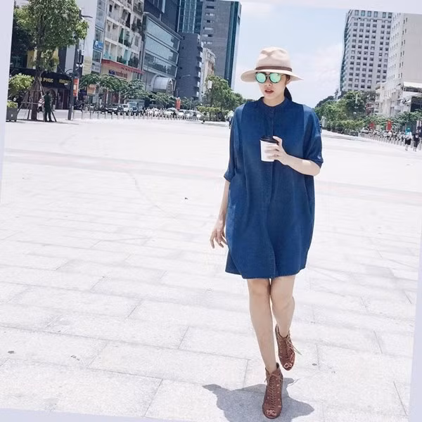 Trong một bối cảnh khác trên phố đi bộ Nguyễn Huệ, cô nàng lựa chọn đầm dáng rộng mang sắc xanh denim khỏe khoắn, kết hợp cùng đôi sandals cao gót cá tính, mạnh mẽ.