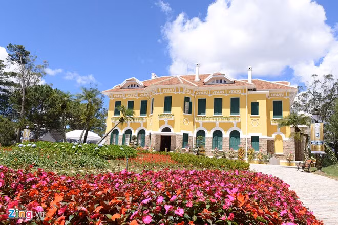 Căn biệt thự cổ kính được sơn sửa lại đúng màu nguyên bản thời kỳ vua Bảo Đại sử dụng. Phía trước là một vườn hoa lớn.