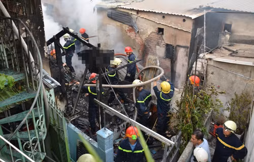 Cảnh sát PCCC đưa thi thể nam thanh niên bị kẹt trong đám cháy ra ngoài.