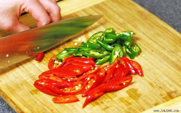 Bước 1, rửa sạch các nguyên liệu đã chuẩn bị sẵn. Ớt cắt lát chéo trong khi thịt lợn cần thái lát mỏng. Lưu ý để thịt khô ráo trước khi chế biến.