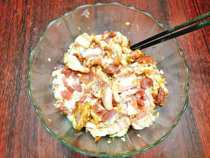 Bước 2, cho thịt lợn vào tô nêm muối, gia vị tạo mùi gà, hạt tiêu, gừng, nước tương đen cùng chút dầu ăn ướp trong vòng 10 phút.