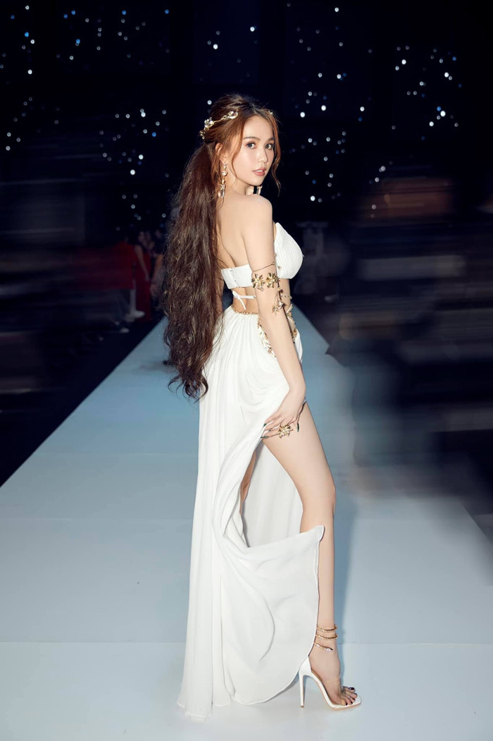 Suối tóc dài xoăn nhẹ cùng cách trang điểm nhẹ nhàng vô cùng ăn khớp với trang phục.