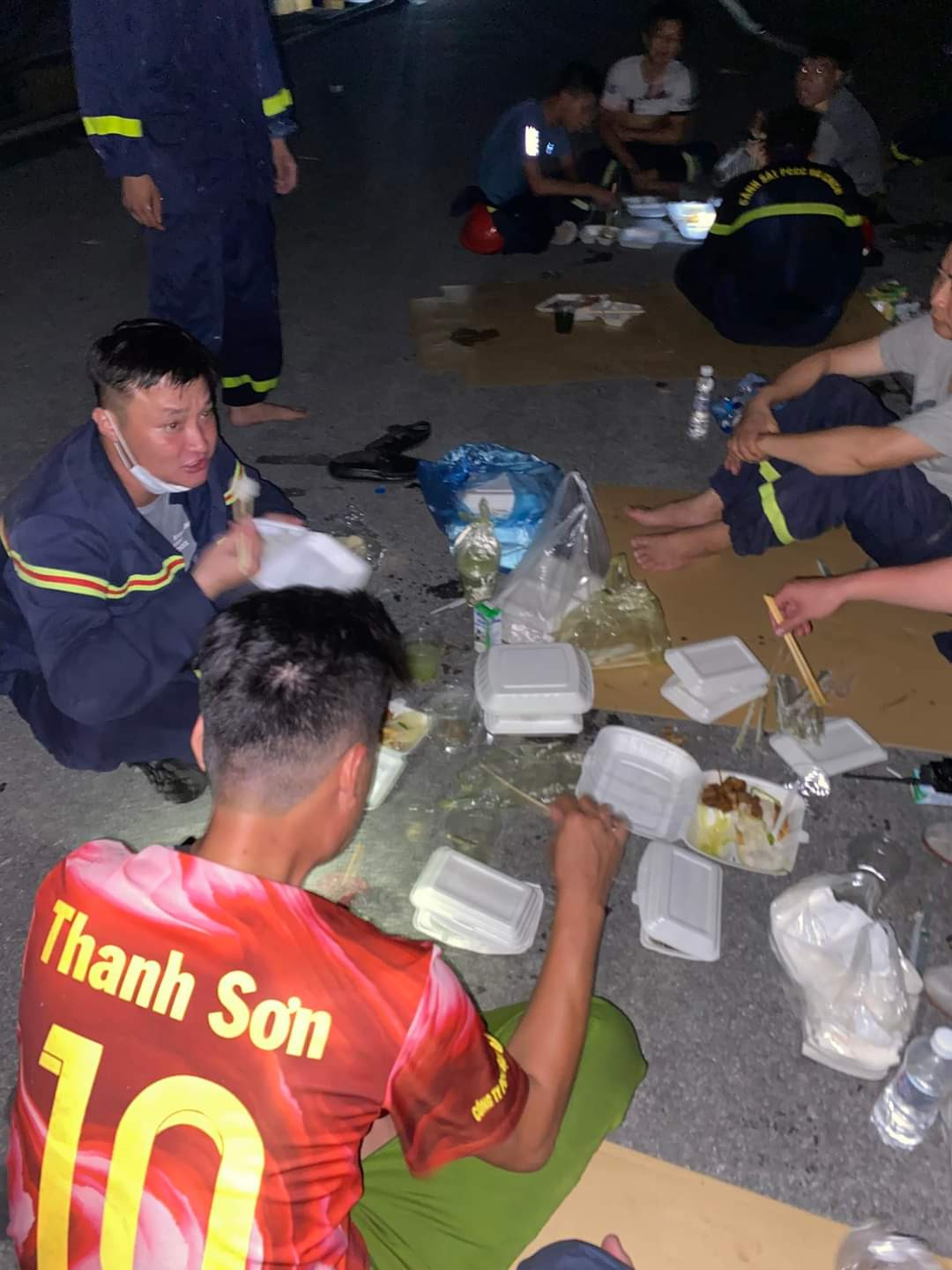 Sau một ngày căng mình chữa cháy, các chiến sĩ cảnh sát PCCC của công an TP Hải Phòng ăn vội suất cơm hộp ngay tại hiện trường. Ảnh: CTV