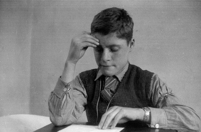 Một bé trai người Đức ngồi học tiếng Anh sau khi tới Dovercourt, Anh.