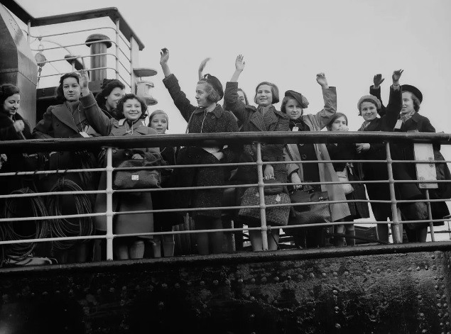 Những đứa trẻ vẫy tay chào cha mẹ để lên tàu tới Anh.