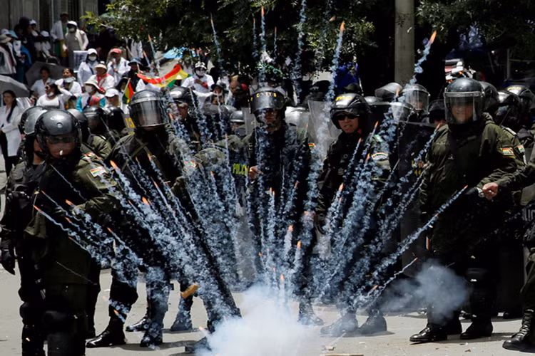 Pháo nổ ngay bên cạnh các nhân viên an ninh Bolivia trong cuộc biểu tình phản đối chính sách chăm sóc sức khỏe mới của chính phủ Bolivia. Nguồn ảnh: TASS.