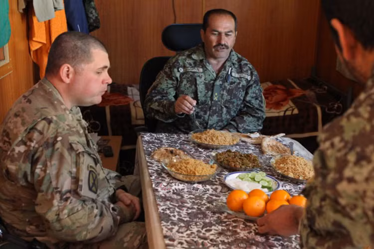 Một trong những niềm vui nhỏ của lính Mỹ khi đóng quân ở Afghanistan đó là khi Giáng sinh đến họ sẽ được các binh sĩ Afghanistan đãi món thịt dê truyền thống của nước này, nó thực sự rất ngon. Việc chia sẻ đồ ăn cũng giúp binh sĩ giảm bớt sự cô đơn trong những ngày nghỉ lễ. Nguồn ảnh: Post-Dispatch.