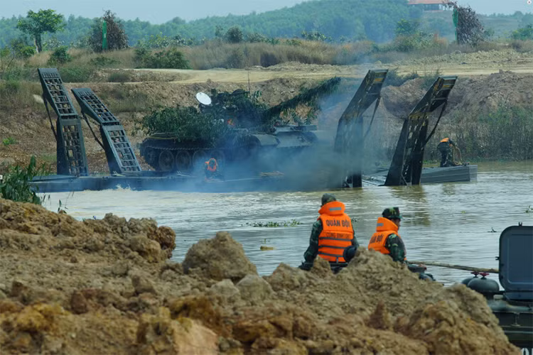 Xe tăng T-55 được công binh hỗ trợ vượt vật cản nước bằng các phương tiện đặc chủng.