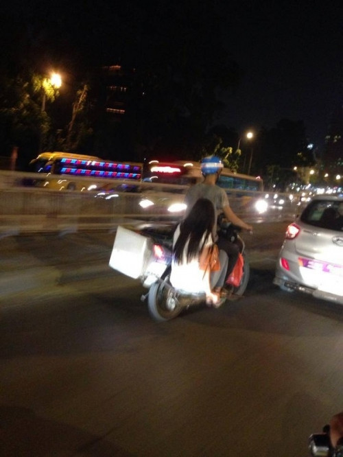 Một bên chàng trai chở thùng hàng, còn bên kia thì chở... cô gái trẻ.