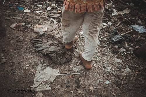 Chân đất nhoi nhói bước đi giữa biển rác mênh mông của đứa trẻ.