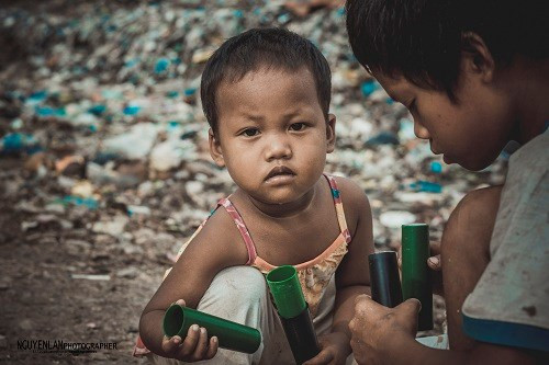 Những đứa trẻ thất thểu nhặt được những ống nhựa tại bãi.