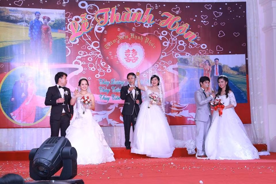 Ba cặp cô dâu - chú rể nâng ly rượu mừng trong ngày đại hỉ. Ở Việt Nam từng có chuyện hai chị sinh đôi cưới hai anh em sinh đôi cùng ngày, còn ba chị em ruột đều là con gái tổ chức chung đám cưới thì thật hiếm thấy.