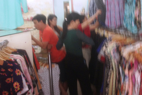 Cả 2 phụ nữ đi vào shop thời trang "làm nhiệm vụ" mua sắm áo, quần.