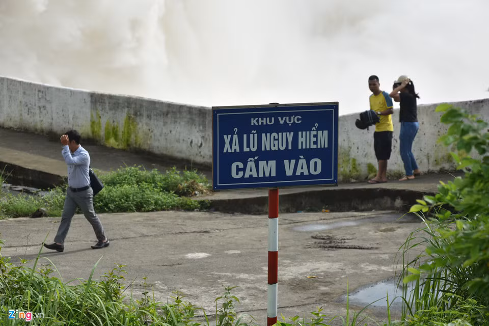 Sát nơi xả lũ có biển cấm vào và chăng dây từ xa nhưng không ngăn được những du khách hiếu kỳ.