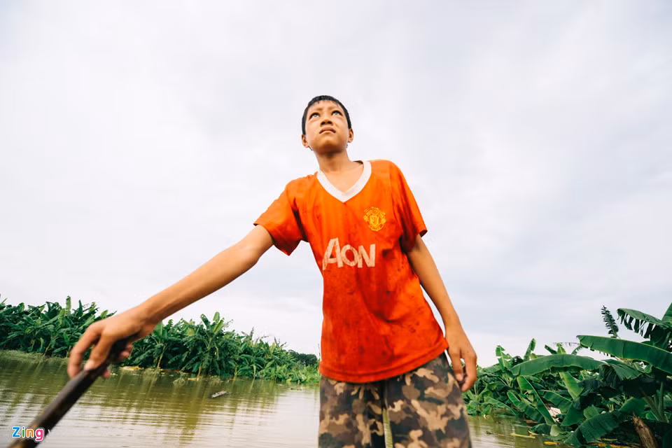 “Em chỉ mong nước rút nhanh để bố mẹ đi chợ đỡ cực hơn thôi”, đôi mắt của cậu bé 14 tuổi chăm chăm nhìn về phía biển nước mênh mông mà mấy ngày trước vẫn là con đường mòn quen thuộc.