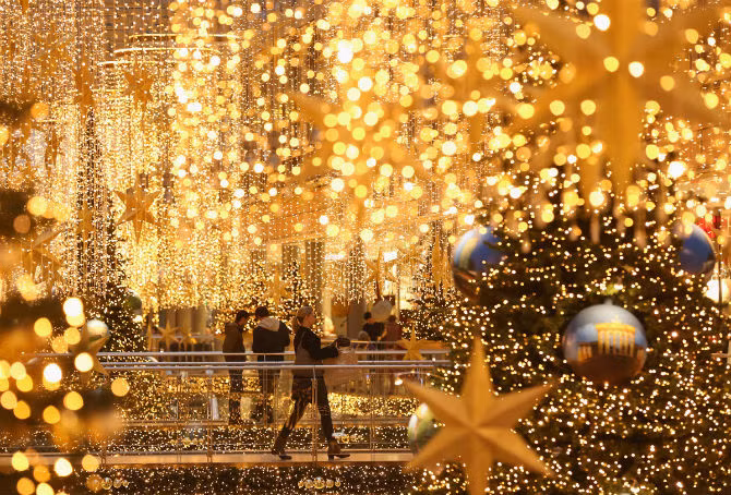 Khách mua sắm hòa vào không khí Giáng sinh tại một trung tâm thương mại ở thủ đô Berlin, Đức ngày 22/12.