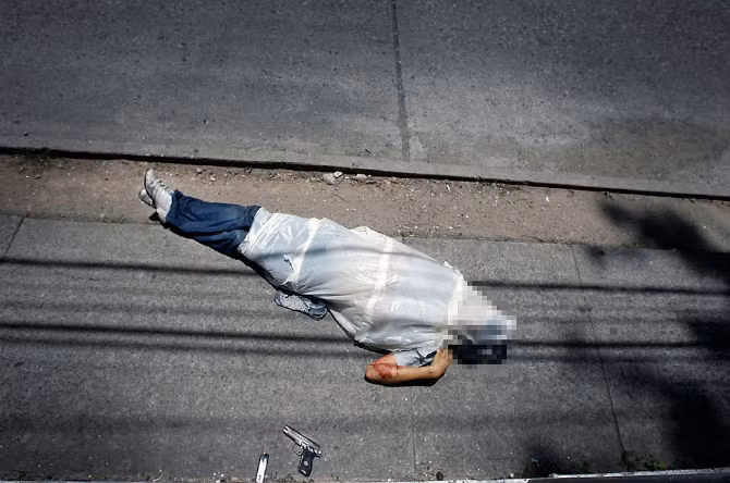 Thi thể một người đàn ông nằm trên đường phố ở thành phố Guatemala với khẩu súng bên cạnh. Có tới 60% dân số nước này sở hữu vũ khí - một yếu tố khiến tỉ lệ giết người cao.