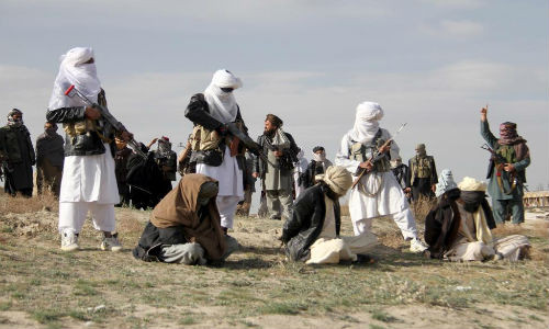 Các phần tử nổi dậy Taliban cầm súng AK-24 chuẩn bị hành quyết ba người đàn ông bị trói tay và bịt mắt tại tỉnh Ghazni ngày 18/4/2015. Phiến quân Taliban cáo buộc những người đàn ông này đã giết hai người khi thực hiện một vụ cướp.