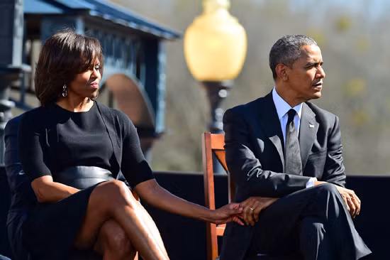 Vợ chồng ông Obama nắm tay nhau khi lắng nghe bài phát biểu tưởng niệm 50 năm biến cố "Bloody Sunday", một cuộc biểu tình đòi quyền lợi tại bang Alabama.