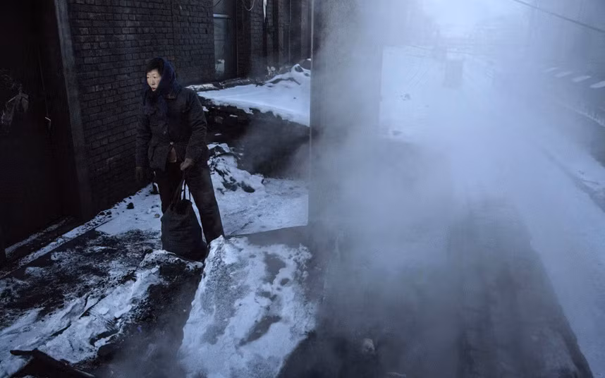 Người phụ nữ thu lượm những mẩu than đá còn vương lại.