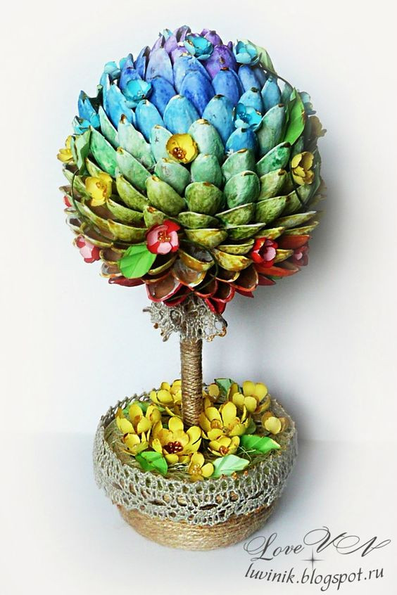 Sử dụng súng bắn keo và gắn vỏ hạt dẻ cười đã nhuộm màu theo vòng tròn xung quanh quả bóng bạn sẽ có một cây hạt dẻ để bàn bắt mắt. Ảnh: pinterest.com.