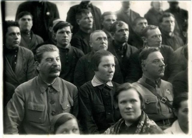 Nhà lãnh đạo Liên Xô ngồi cùng với mọi người và chăm chú theo dõi một sự kiện.